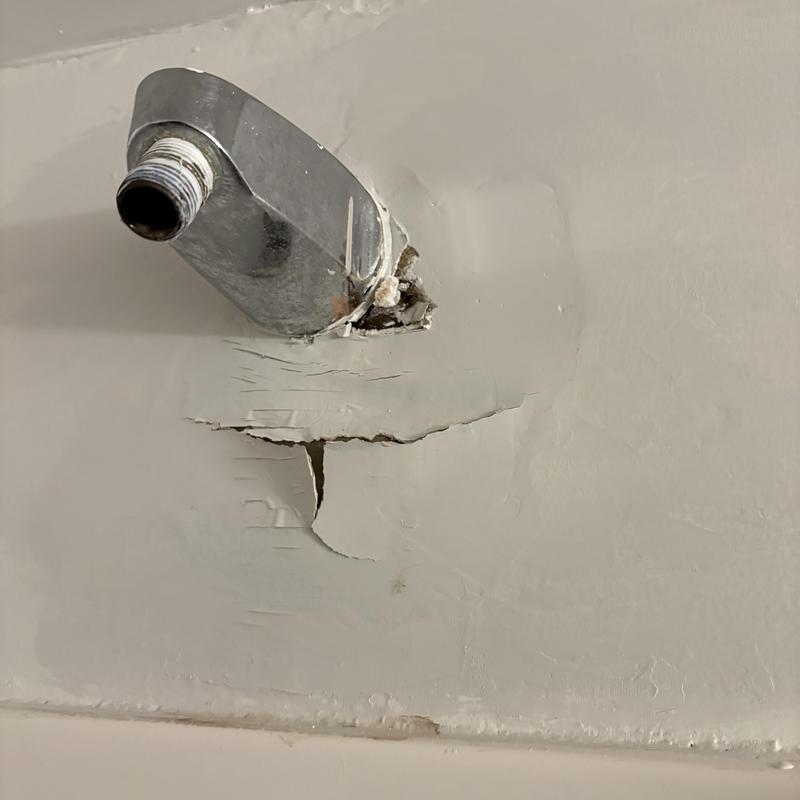 Shower arm pipe with wall damage and corrosion