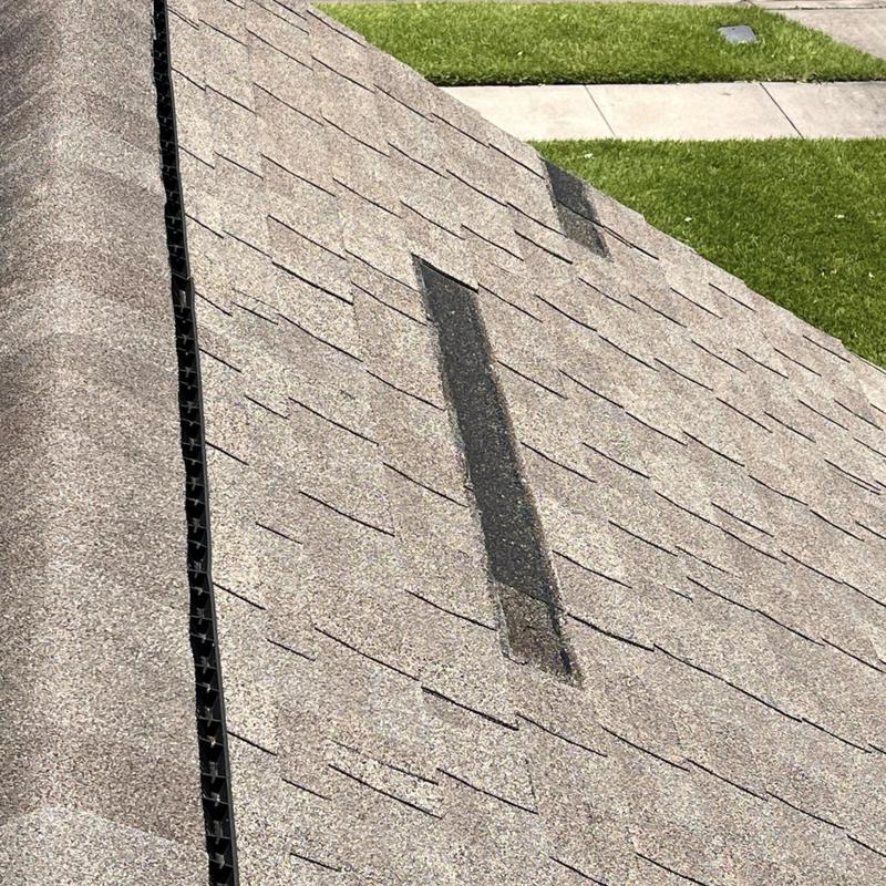 Asphalt shingles with replaced patches on residential roof Asphalt shingles with replaced patches on residential roof