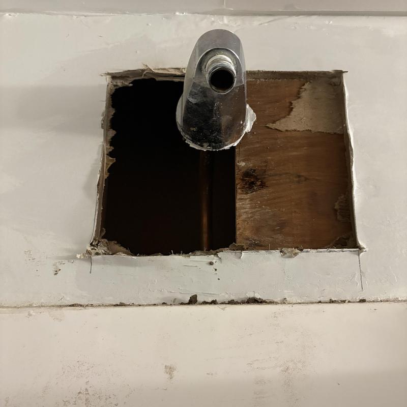 60s style shower arm and exposed pipework in wall cavity