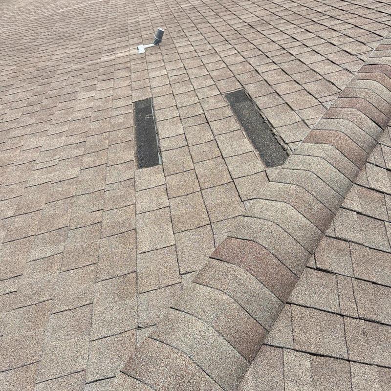 Asphalt shingles with damaged patch areas on roof Asphalt shingles with damaged patch areas on roof