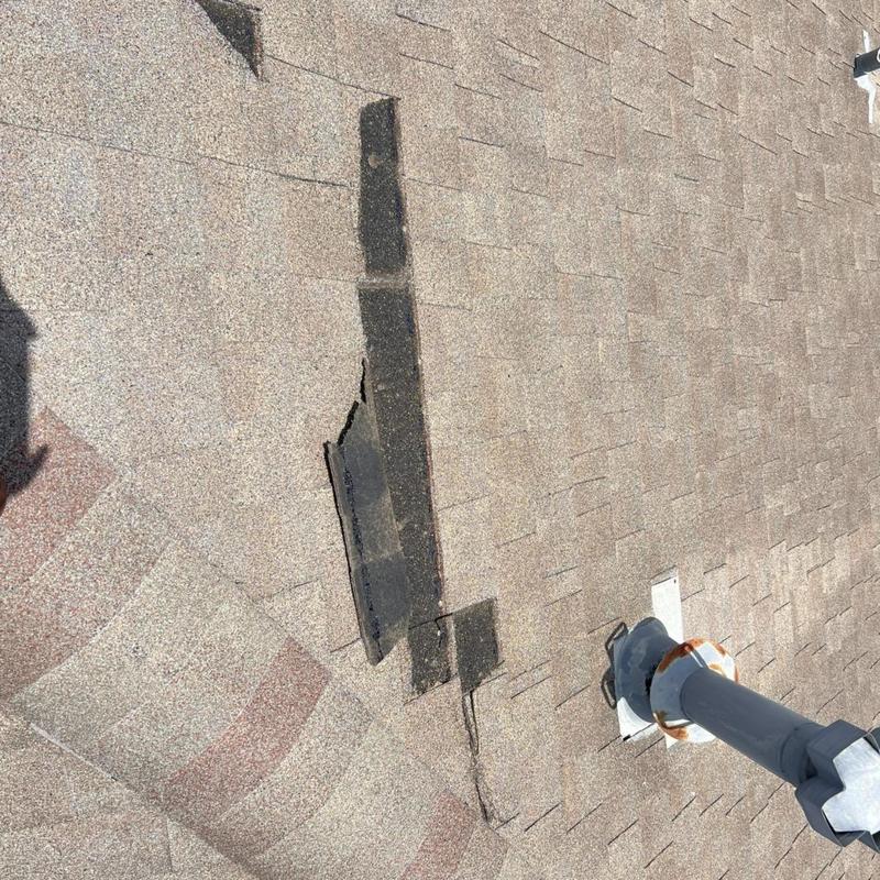 Asphalt shingles with damaged patches near roof vent pipe Asphalt shingles with damaged patches near roof vent pipe
