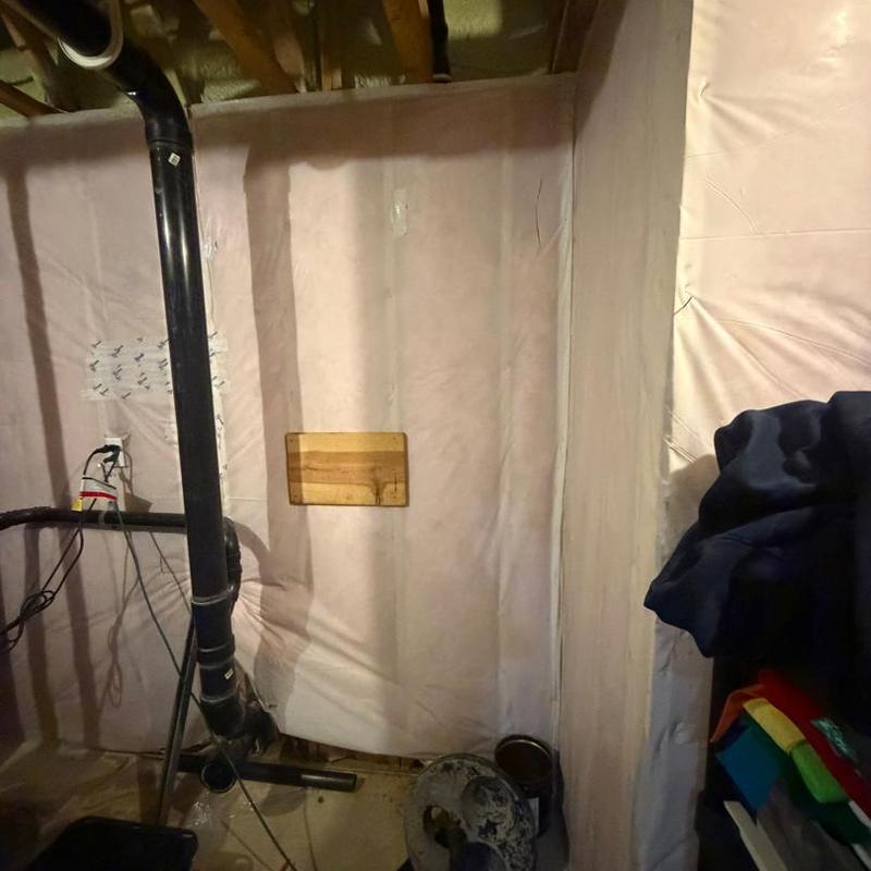 Sump pump discharge pipe installation in basement corner