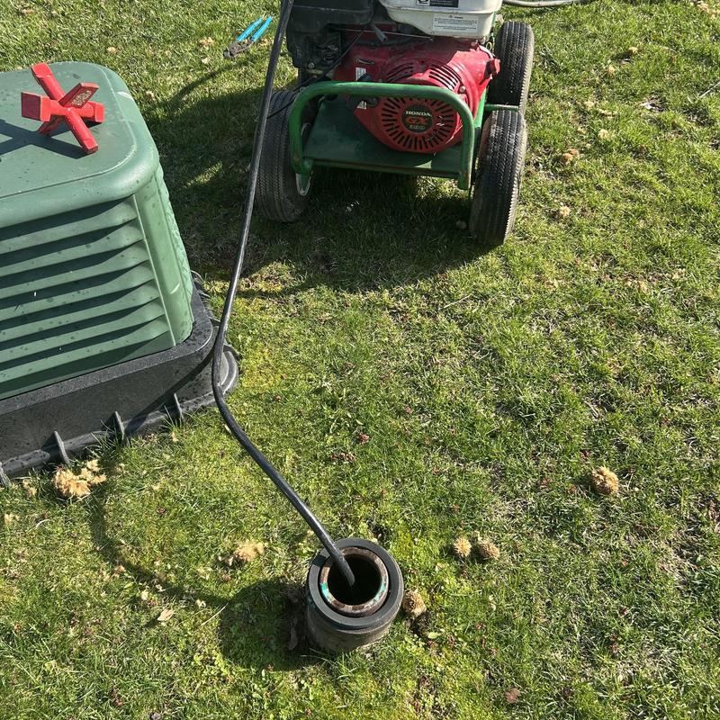 Sewer cleanout jetting machine on lawn next to riser Sewer cleanout jetting machine on lawn next to riser
