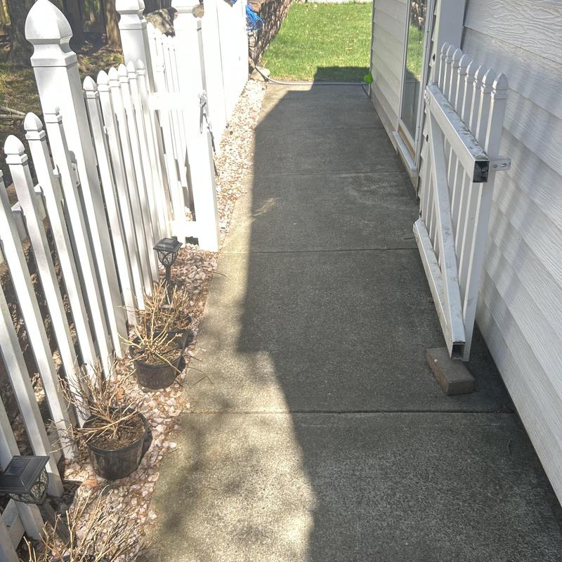 Concrete walkway with white picket fences on sides Concrete walkway with white picket fences on sides