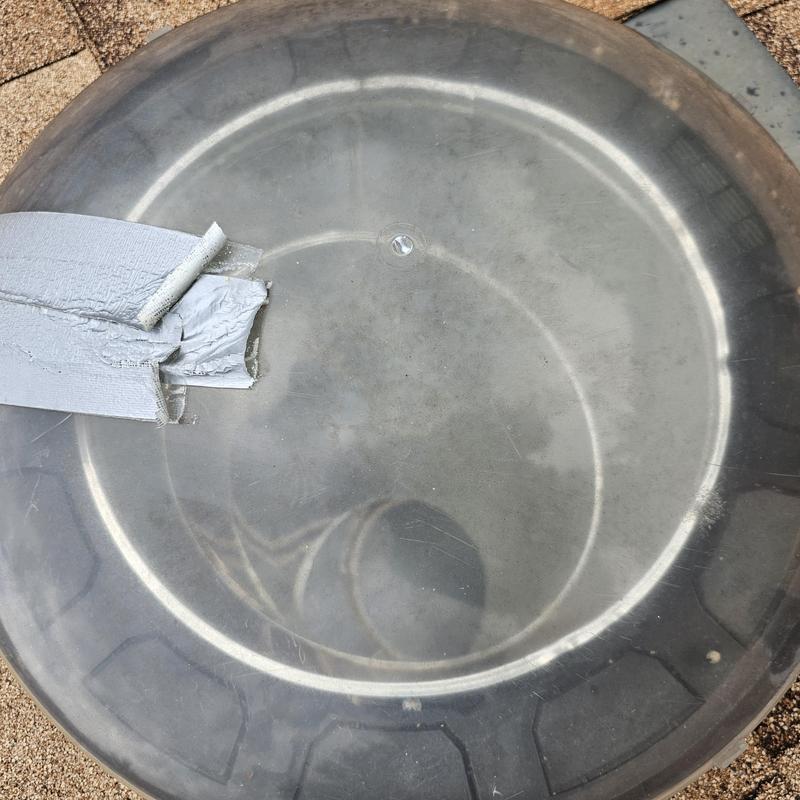 Tire cover with duct tape on gravel roof shingles