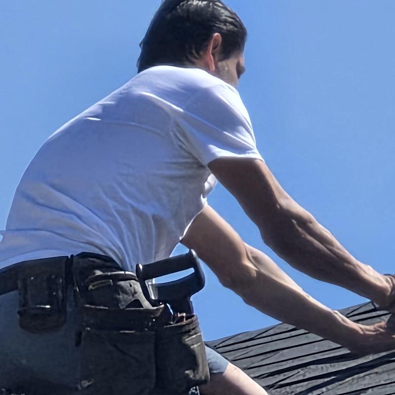 Roof shingles replacement on residential roof under clear sky