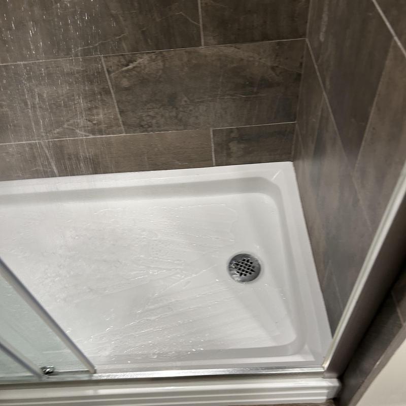 Shower drain with water jet cleaning in tiled stall Shower drain with water jet cleaning in tiled stall