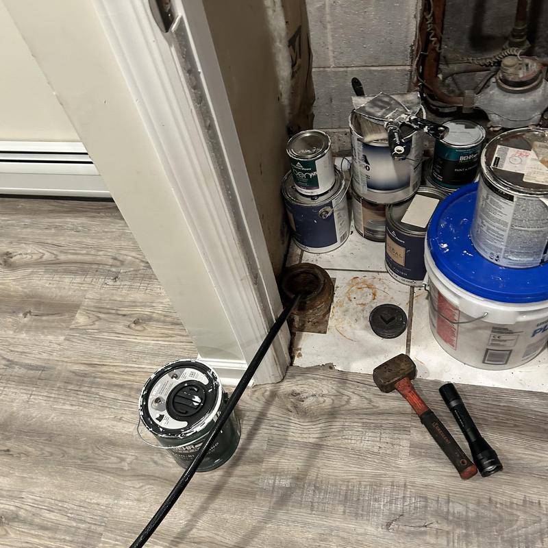 Drain jetting rod in floor drain with tools nearby Drain jetting rod in floor drain with tools nearby