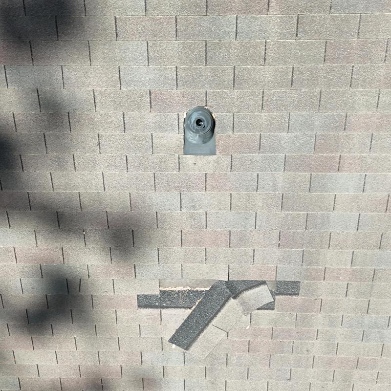 Three-tab roof shingles with damaged patches and pipe boot
