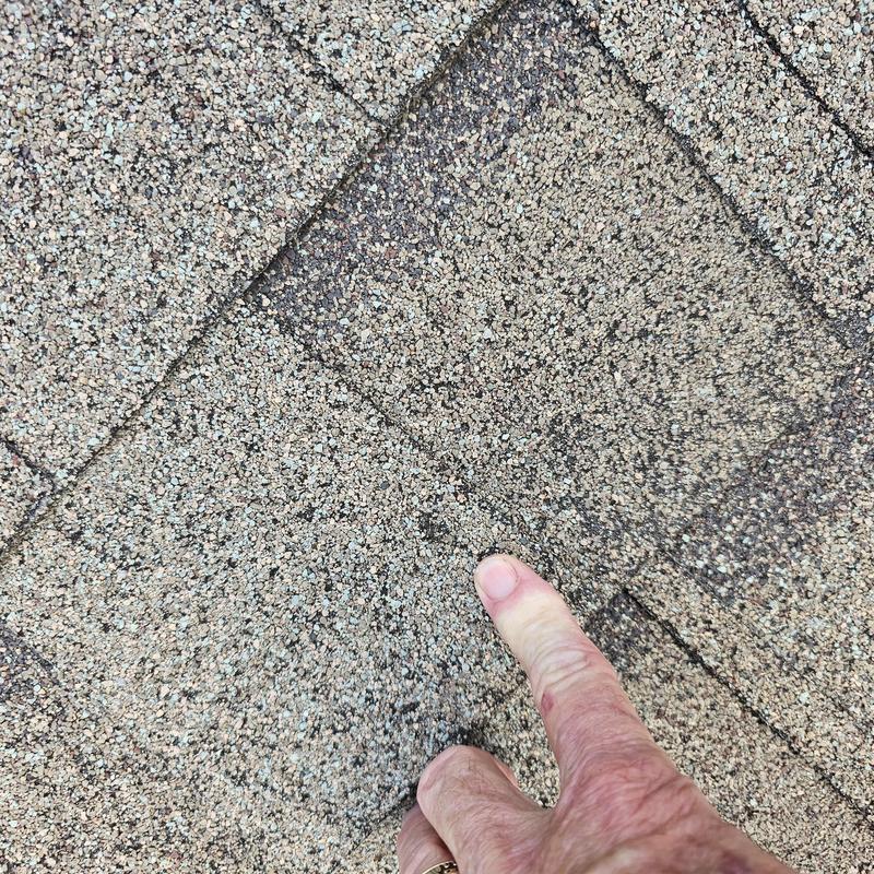 Asphalt roof shingles with hail damage close-up