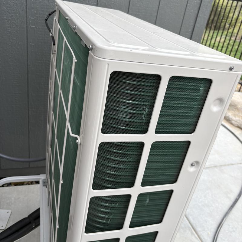 Outdoor HVAC condenser unit with protective grille