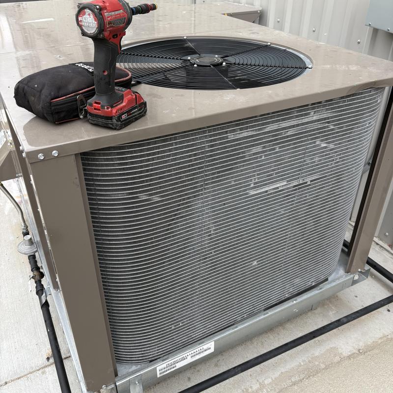 Commercial HVAC condenser unit with power drill on top