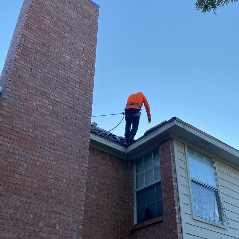 Metal roof edge with roofer in safety harness Metal roof edge with roofer in safety harness