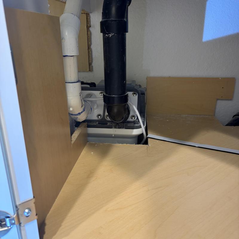 Ejector pump with black and white drain pipes under cabinet Ejector pump with black and white drain pipes under cabinet