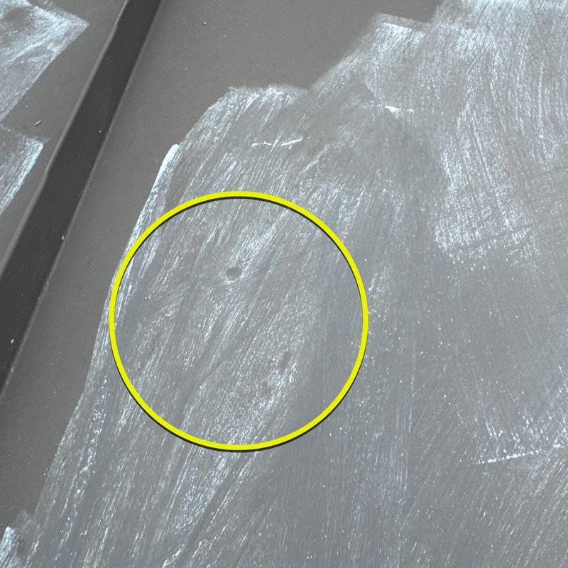 Metal roof hail damage marks highlighted in yellow circle
