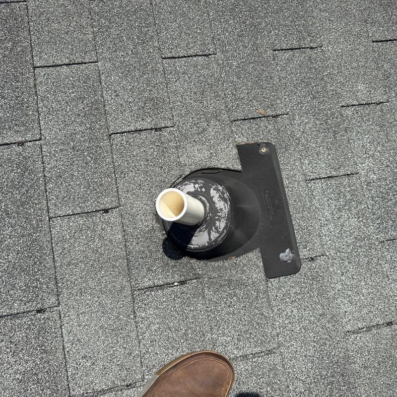 Roof vent pipe flashing on shingled roof with damage