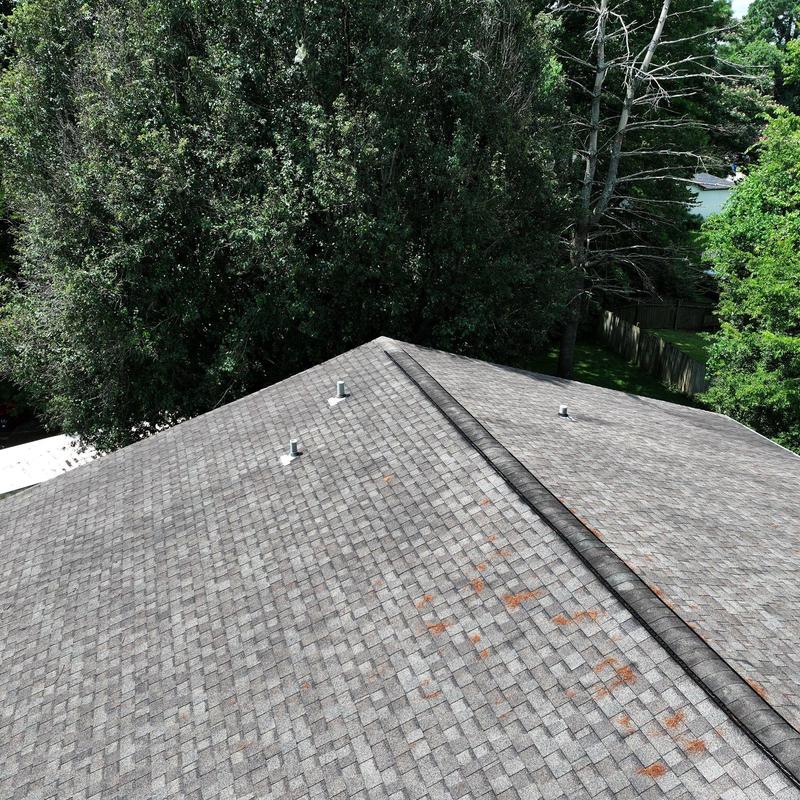 Asphalt shingle roof with hail damage and rust spots
