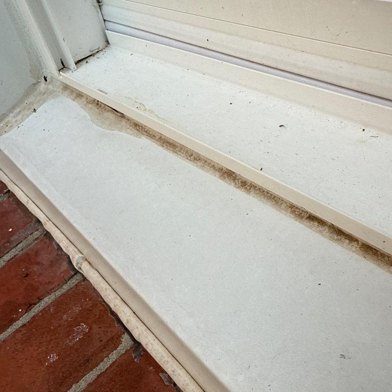 Window sill with water damage and dirt buildup