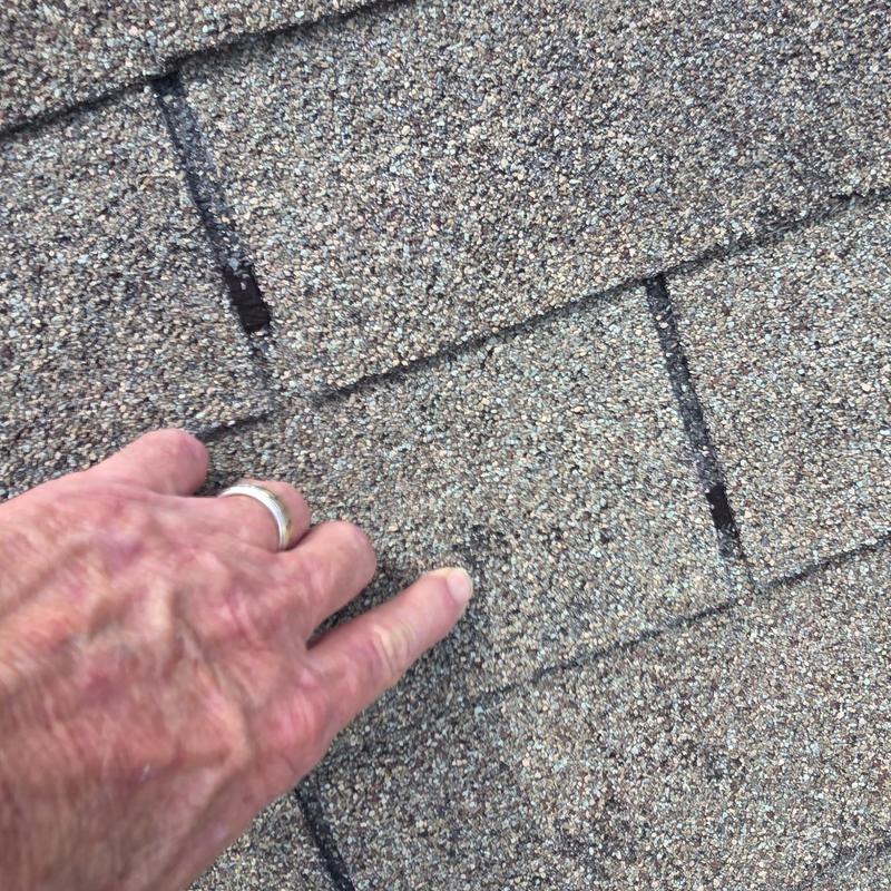 Asphalt roof shingles with hail damage close-up