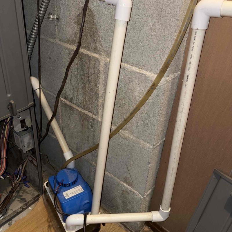 Condensate pump and PVC drain pipes near furnace unit Condensate pump and PVC drain pipes near furnace unit