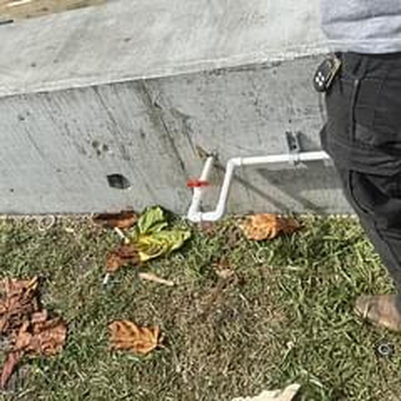 Outdoor water pipe and valve installation near foundation