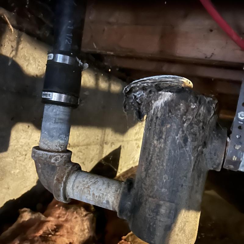 Drain pipe with rust and corrosion under floor joists Drain pipe with rust and corrosion under floor joists