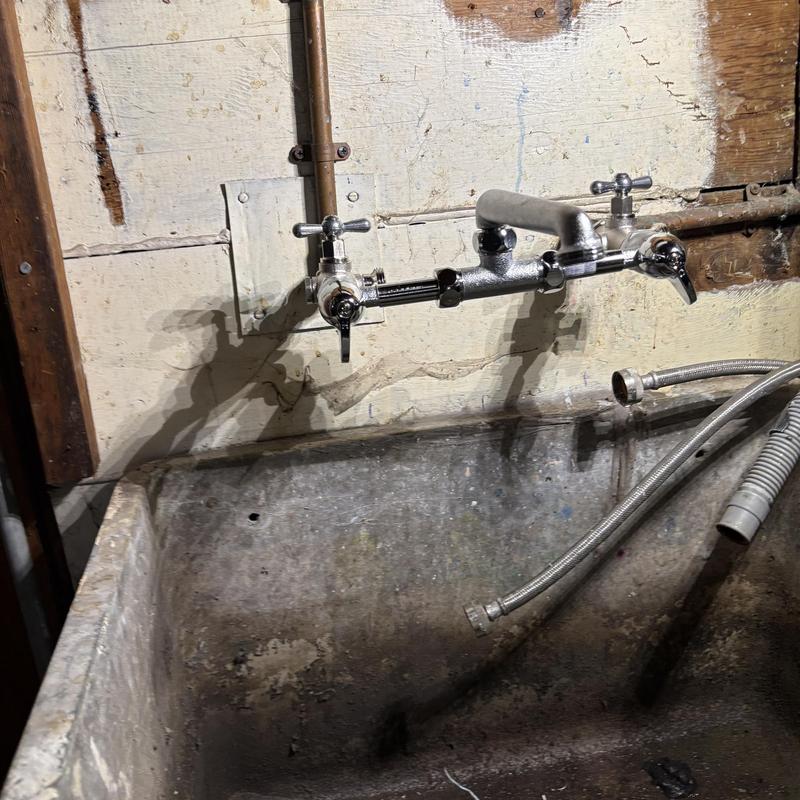 Laundry sink faucet and valves installed above basin