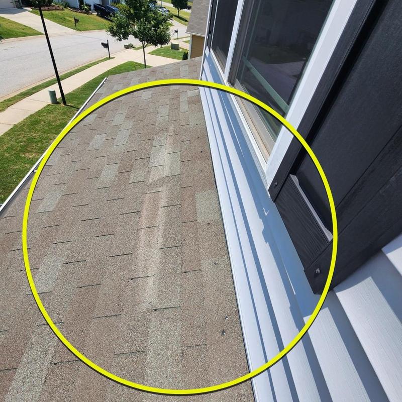 Asphalt shingle roof section near window with possible leak area