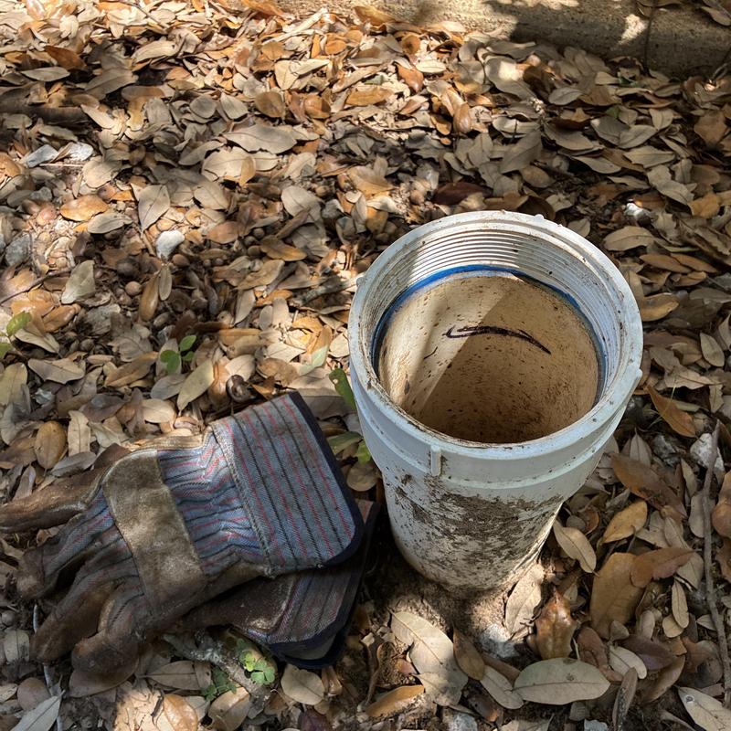 Sewer cleanout pipe with work gloves outdoors
