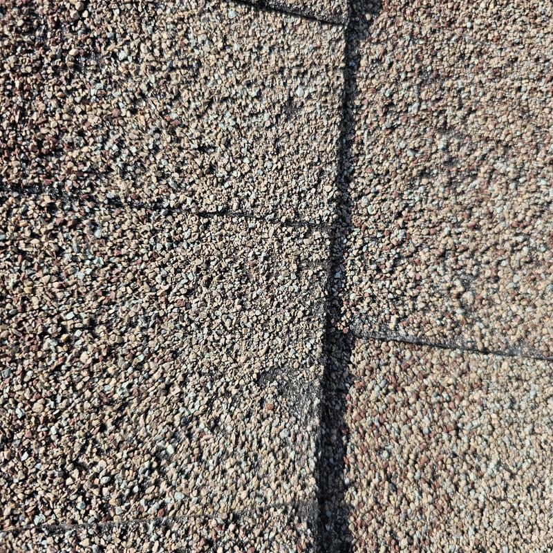 Roof shingles with visible hail impact damage close-up