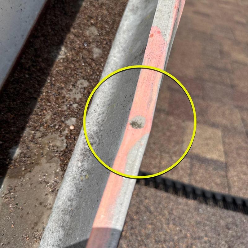 Metal gutter with hole from hail damage