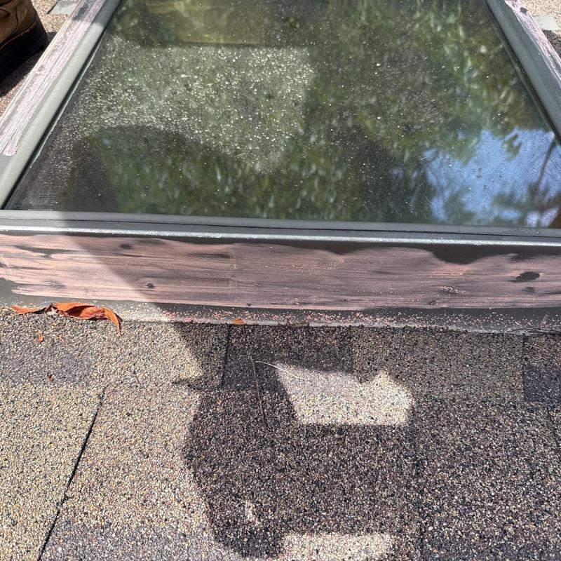 Skylight frame with weathered wood and roof shingles