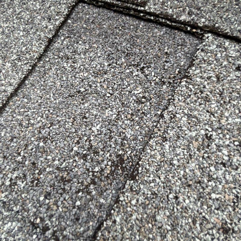 Asphalt shingle roof with hail damage signs close-up