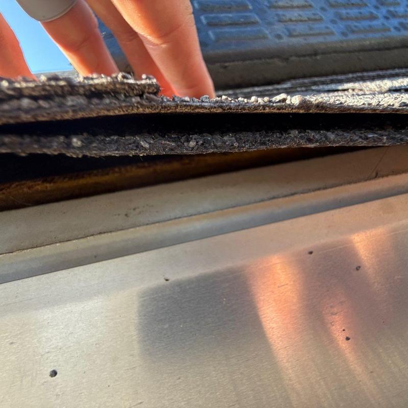 Roof shingles with hail damage and flashing displacement