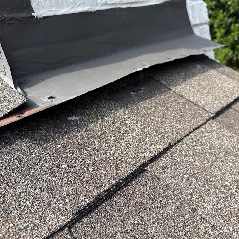 Roof shingles and flashing showing hail damage