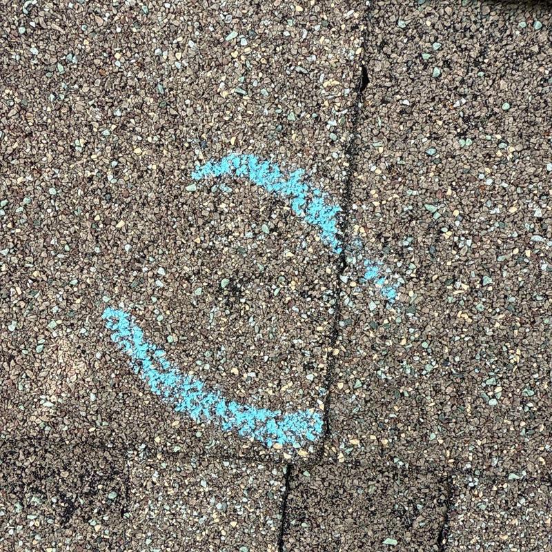 Asphalt roof shingles with marked hail damage