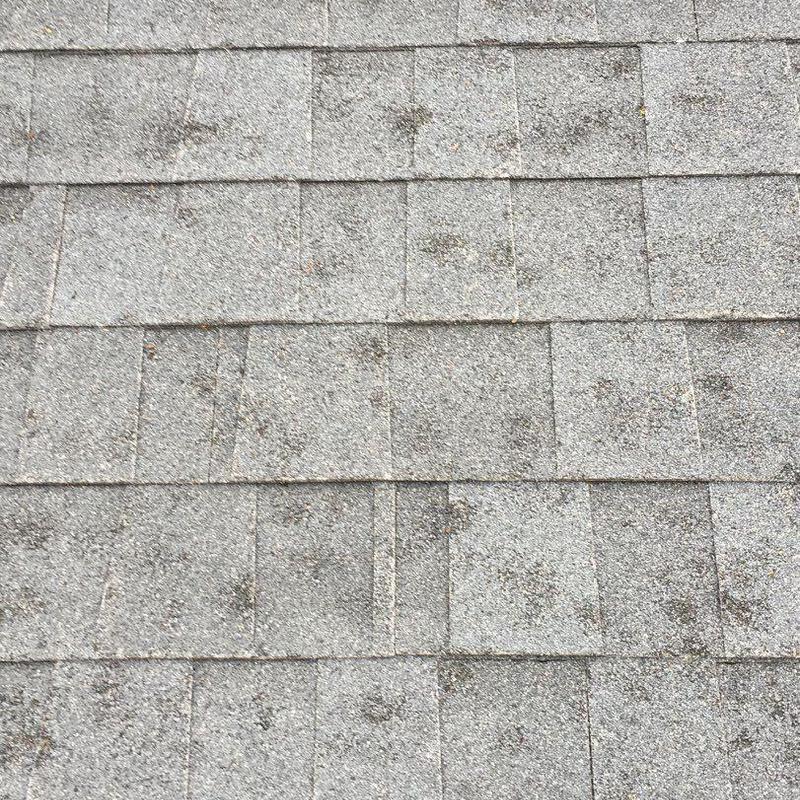 Roof shingles with hail damage spots close-up Roof shingles with hail damage spots close-up