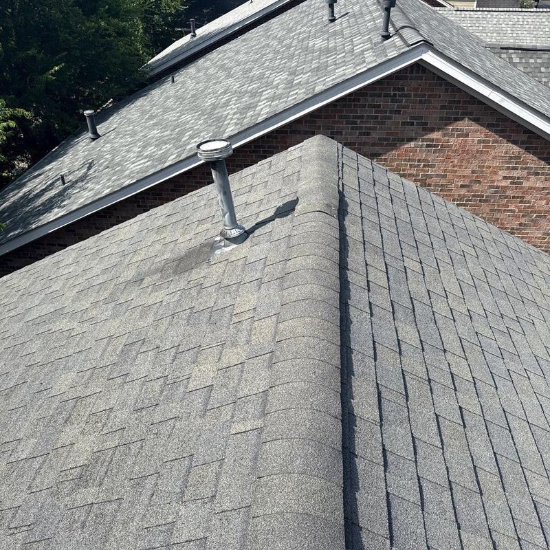 Asphalt shingle roof with vent pipe and ridge cap