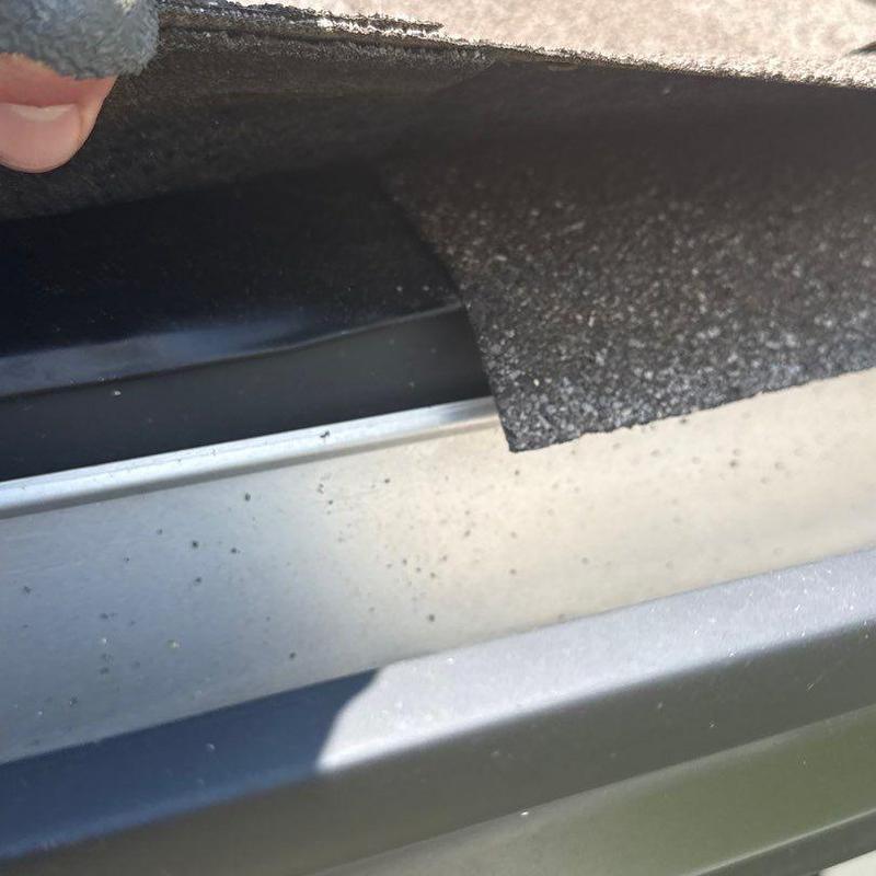 Roof shingle edge lifted above metal drip edge installation