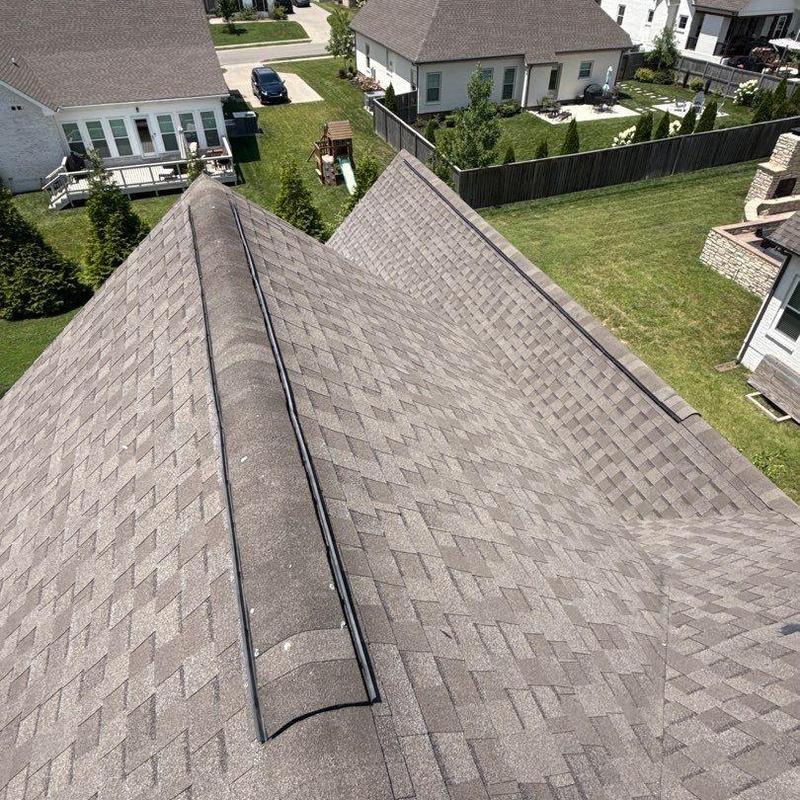 Asphalt shingle roof with ridge cap and hail damage