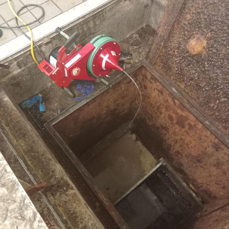 Main line sewer cleaning machine in maintenance pit