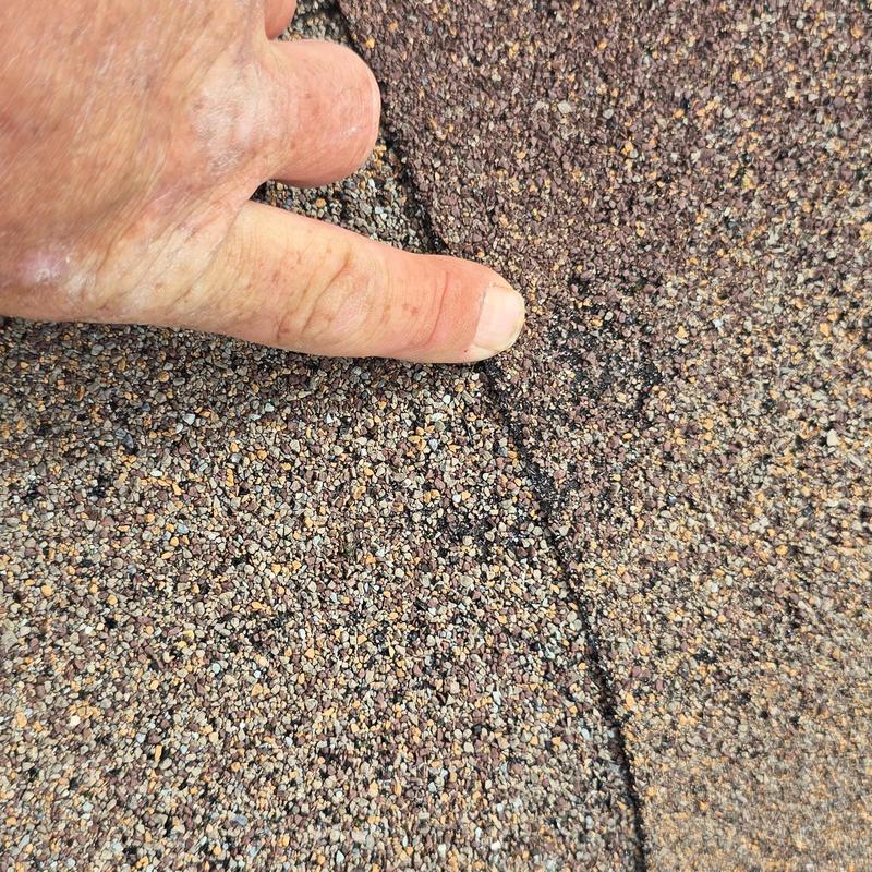 Asphalt shingle roof hail damage close-up inspection