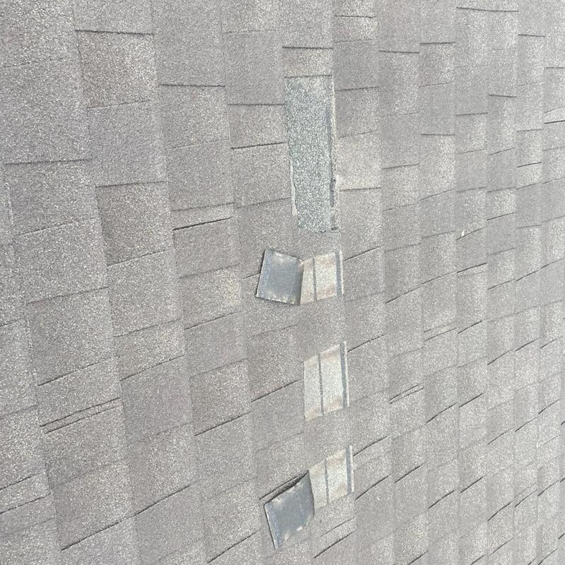Roof shingles with visible hail impact damage