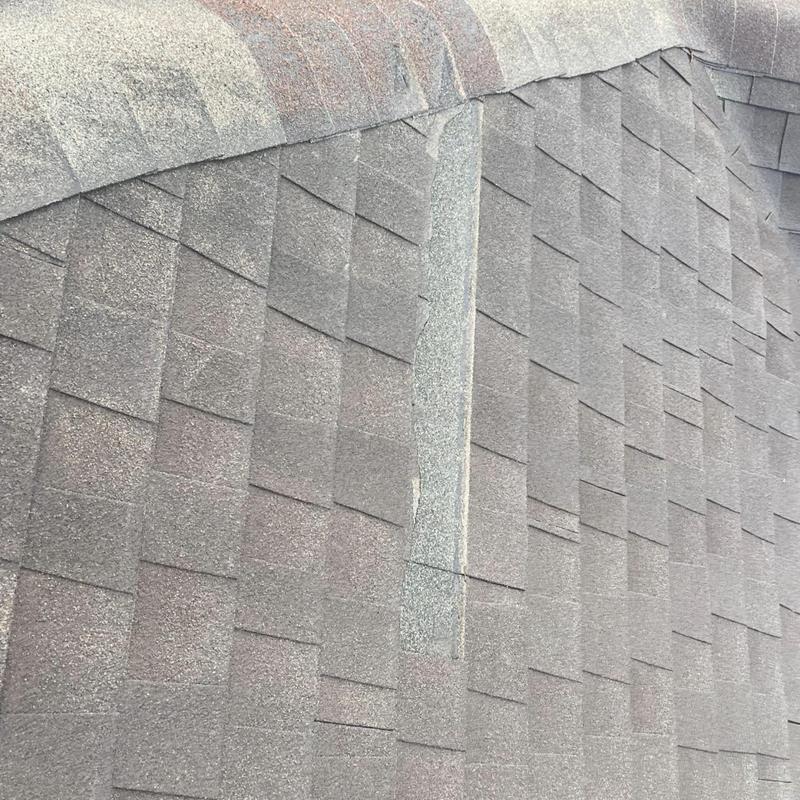Asphalt roof shingles with damaged ridge sealant