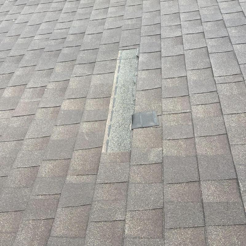 Asphalt shingles with one missing shingle on roof