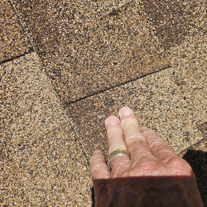 Asphalt roof shingles with hail damage close-up