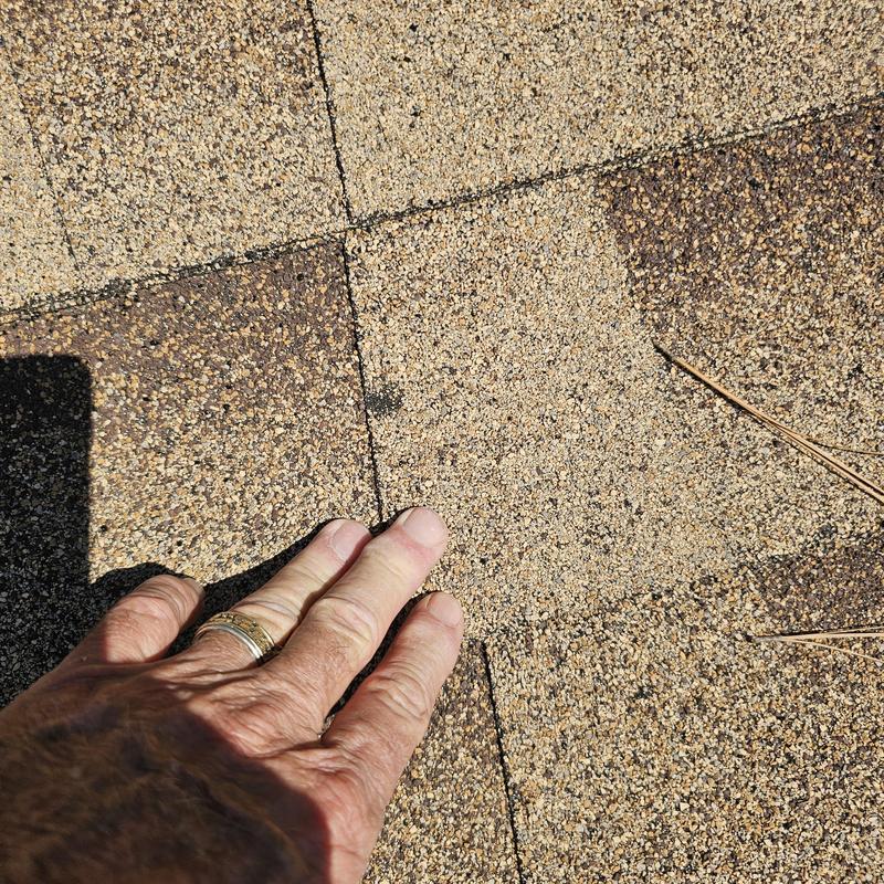 Asphalt roof shingles with hail damage close-up