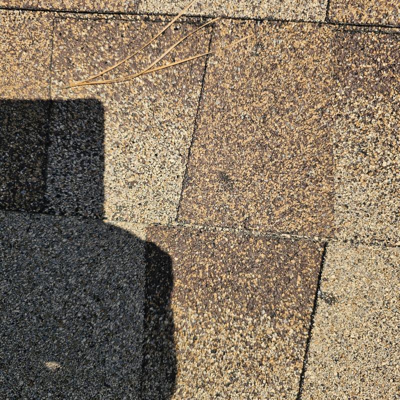 Asphalt roofing shingles with hail damage close-up