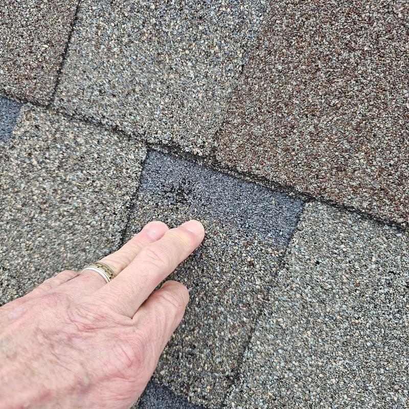 Asphalt shingle roof showing hail damage close-up
