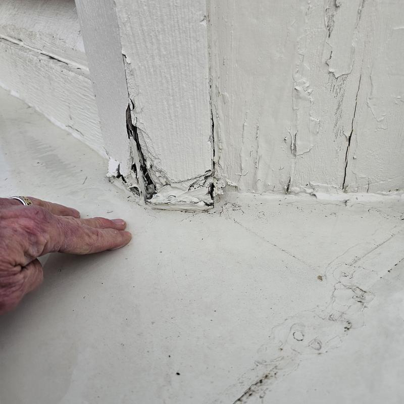 Exterior wood siding damage at base near roof edge